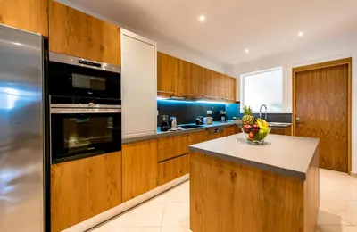 a kitchen with wooden cabinets and a stainless steel refrigerator at CASA DI RODINI in Rhodes Town