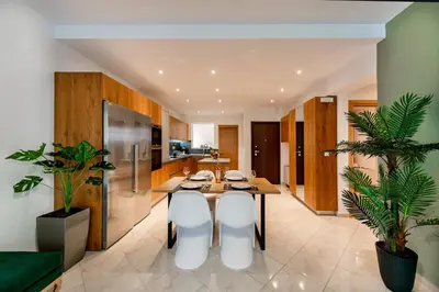 a kitchen with a wooden table and white chairs at CASA DI RODINI in Rhodes Town