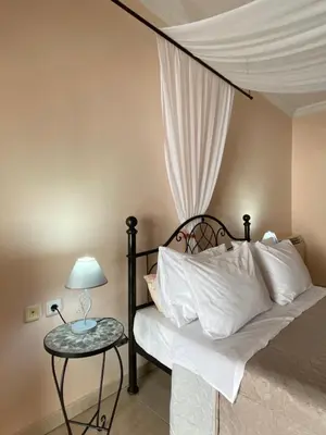 a bedroom with a bed and a table with a lamp at Kasteli Cozy House in Archangelos