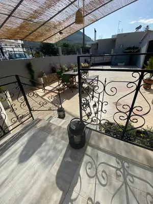 a balcony of a house with a table and chairs at Kasteli Cozy House in Archangelos