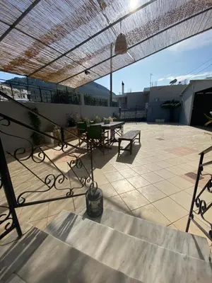 a patio with a table and chairs on a roof at Kasteli Cozy House in Archangelos