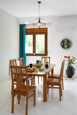 a dining room with a wooden table and chairs at Villa Iasama in Rhodes Town