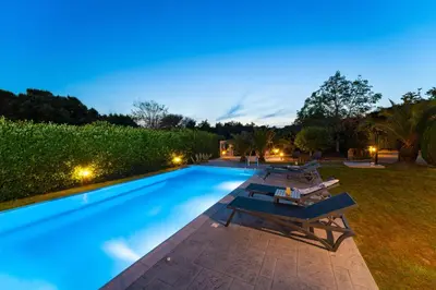a large swimming pool with lounge chairs around it at Villa Iasama in Rhodes Town