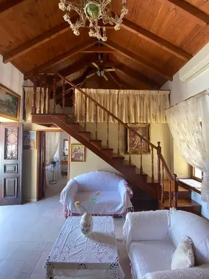 a living room with a staircase and a couch at Traditional Villa Christos & Tholos In Chalki in Halki