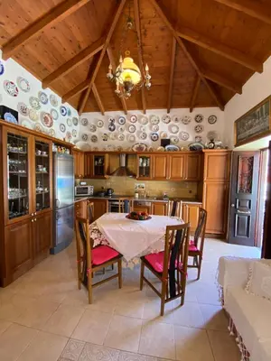 a kitchen with a table and chairs and a chandelier at Traditional Villa Christos & Tholos In Chalki in Halki