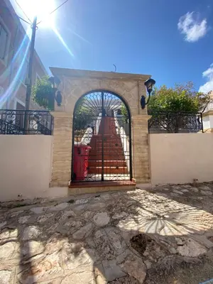 a gate with a fountain in front of a building at Traditional Villa Christos & Tholos In Chalki in Halki