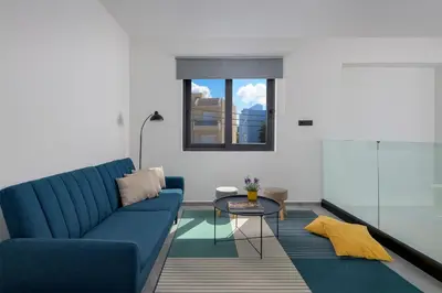 a living room with a blue couch and a table at Villa Incerto in Ialyssos