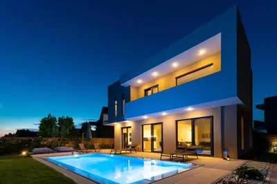 a villa with a swimming pool at night at Villa Incerto in Ialyssos