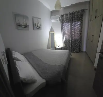 a small bedroom with a bed and a window at Odysseia Stay Pool & Private Jacuzzi 2min Beach in Kremasti