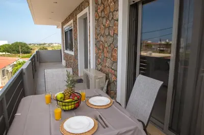a table with a bowl of fruit on a balcony at Odysseia Stay Pool & Private Jacuzzi 2min Beach in Kremasti