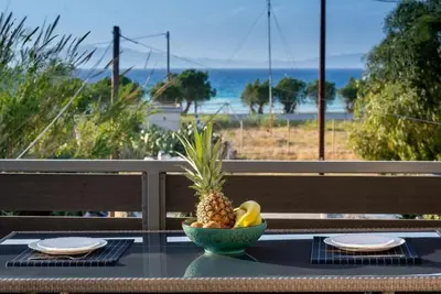 a bowl of pineapple on a table with a view of the beach at Odysseia Stay Pool & Private Jacuzzi 2min Beach in Kremasti