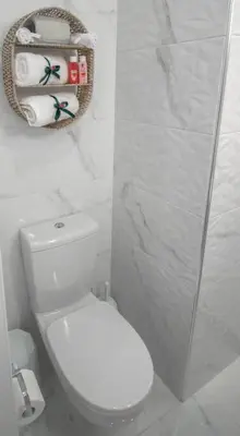 a white bathroom with a toilet and a mirror at Fileo Family and Friends Living in Archangelos