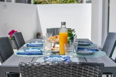 a table with plates of food and a bottle of orange juice at Fileo Family and Friends Living in Archangelos