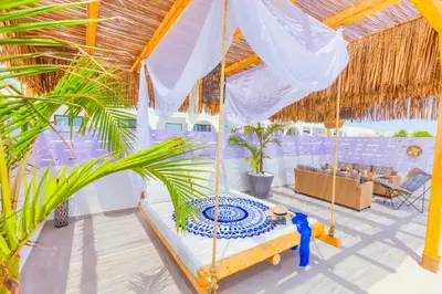 a bedroom with a bed in a straw roof at City Compass Luxury Villa in Faliraki