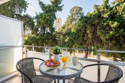 a table with a plate of food on a balcony at Sweet Dream Premium Apartment in Rhodes Town