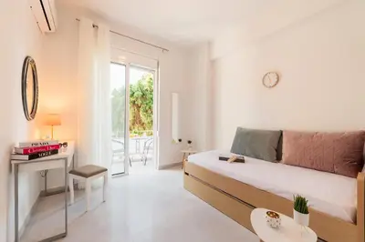 a white bedroom with a bed and a table and a desk at Sweet Dream Premium Apartment in Rhodes Town
