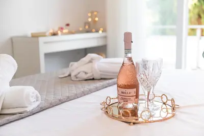a bottle of champagne and a wine glass on a table at Sweet Dream Premium Apartment in Rhodes Town