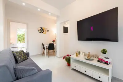 a living room with a couch and a tv on a wall at Sweet Dream Premium Apartment in Rhodes Town