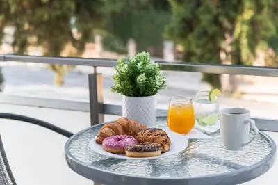 a table with a plate of donuts and a cup of orange juice at Sweet Dream Premium Apartment in Rhodes Town
