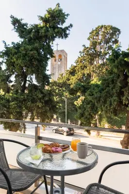 a table with a plate of food on a balcony at Sweet Dream Premium Apartment in Rhodes Town