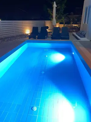 a swimming pool at night with blue lights on it at Casa Christiana, Lardos in Lardos
