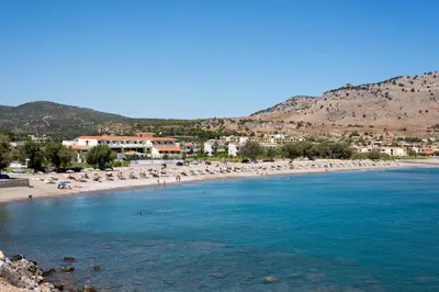 a beach with umbrellas and people in the water at Casa Christiana, Lardos in Lardos