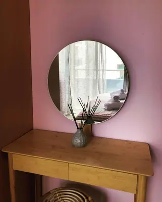 a mirror on top of a wooden table with a vase at Primordial Apartment in Rhodes Town