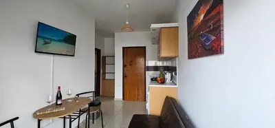 a living room with a table and a kitchen at Primordial Apartment in Rhodes Town