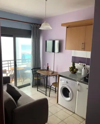 a kitchen and living room with a washing machine at Primordial Apartment in Rhodes Town