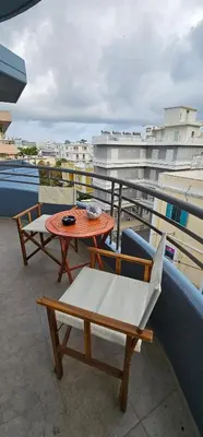 a balcony with a table and chairs on a roof at Primordial Apartment in Rhodes Town