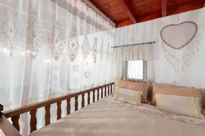 a bedroom with white curtains and a large bed at La casa di Fina in Archangelos