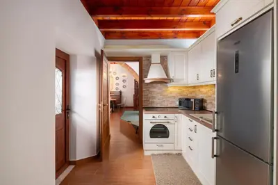 a kitchen with white cabinets and a refrigerator at La casa di Fina in Archangelos