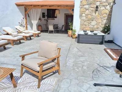 a patio with chairs and a stone fireplace at La casa di Fina in Archangelos