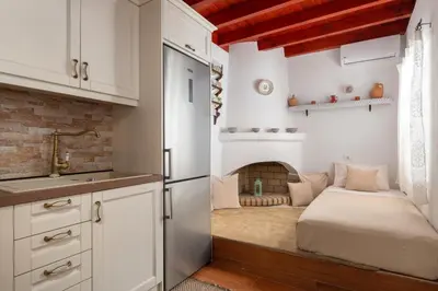 a kitchen with a fireplace in the corner of a room at La casa di Fina in Archangelos