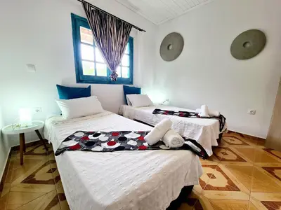 two beds in a room with white walls at Cactus Living in Ialyssos