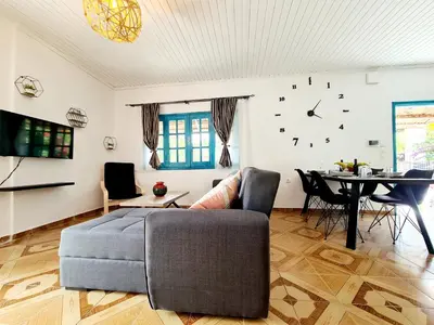 a living room with a couch and a clock on the wall at Cactus Living in Ialyssos
