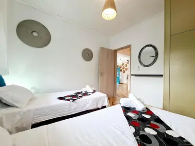 a bedroom with two beds and a mirror at Cactus Living in Ialyssos