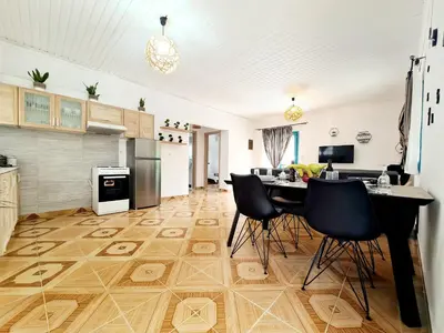 a kitchen with a table and chairs on a wooden floor at Cactus Living in Ialyssos