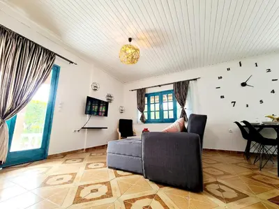 a living room with a couch and a clock on the wall at Cactus Living in Ialyssos