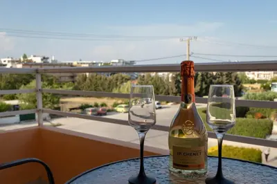 a bottle of wine sitting on a table with two wine glasses at Eugenia Studios & Apartments in Ialyssos