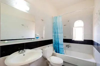 a bathroom with a sink and a toilet and a tub at Eugenia Studios & Apartments in Ialyssos