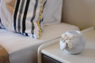 a cup sitting on a table next to a bed at Eugenia Studios & Apartments in Ialyssos