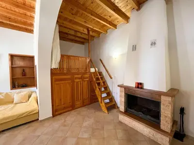 a living room with a fireplace and a staircase at Kostas Village House in Psinthos