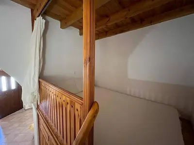 a wooden staircase in a room with a bed at Kostas Village House in Psinthos