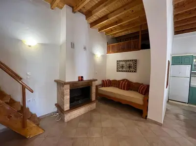 a living room with a couch and a fireplace at Kostas Village House in Psinthos