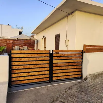 a wooden fence in front of a house at Casa di Rena Private House with Sunset View in Kritinía