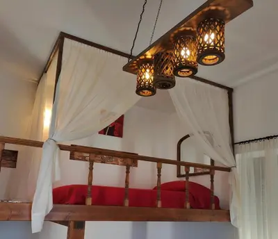 a bedroom with a canopy bed with a chandelier at Casa di Rena Private House with Sunset View in Kritinía
