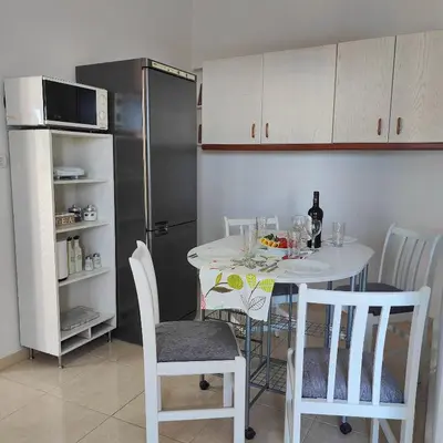 a kitchen with a white table and a refrigerator at Casa di Rena Private House with Sunset View in Kritinía