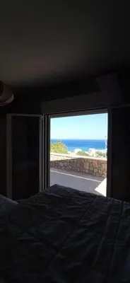 a bedroom with a bed and a view of the ocean at Pasithea Luxury house in Archangelos