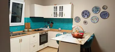 a kitchen with white cabinets and blue tile at Pasithea Luxury house in Archangelos